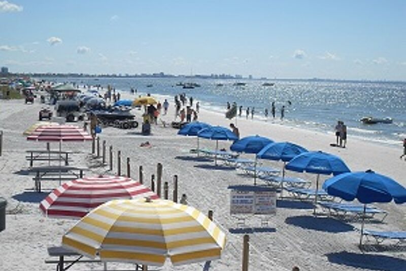 fort myers beach with umbrellas and people